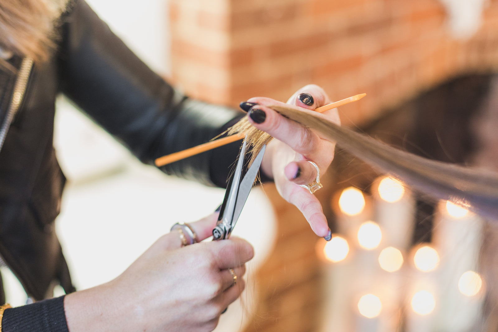 Hair stylist serving a client while waiting customers sit in a modern salon