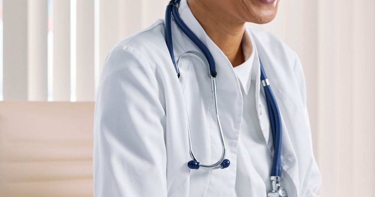 digital token system for diagnostic labs: patient checking a live token number on a phone while waiting away from the collection counter