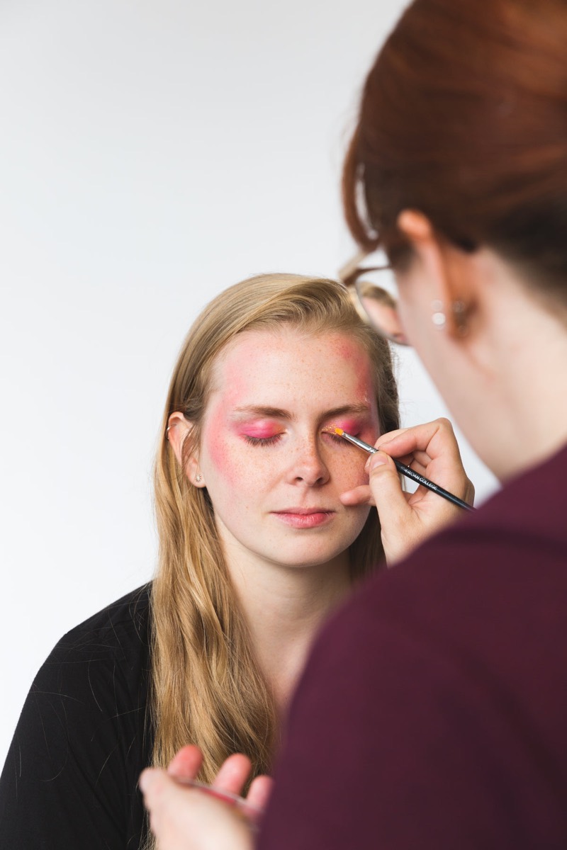 Bridal makeup artist applying makeup to a bride before a wedding