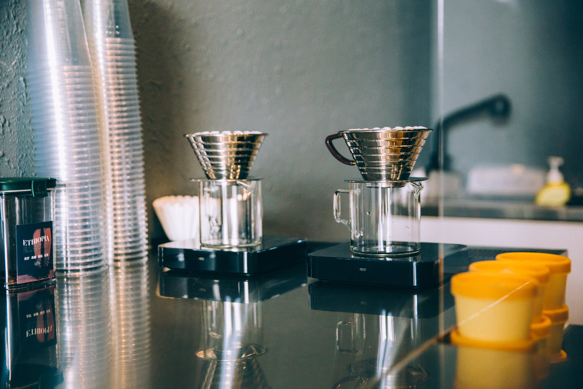 Customers waiting in line at a coffee shop counter while a barista takes an order