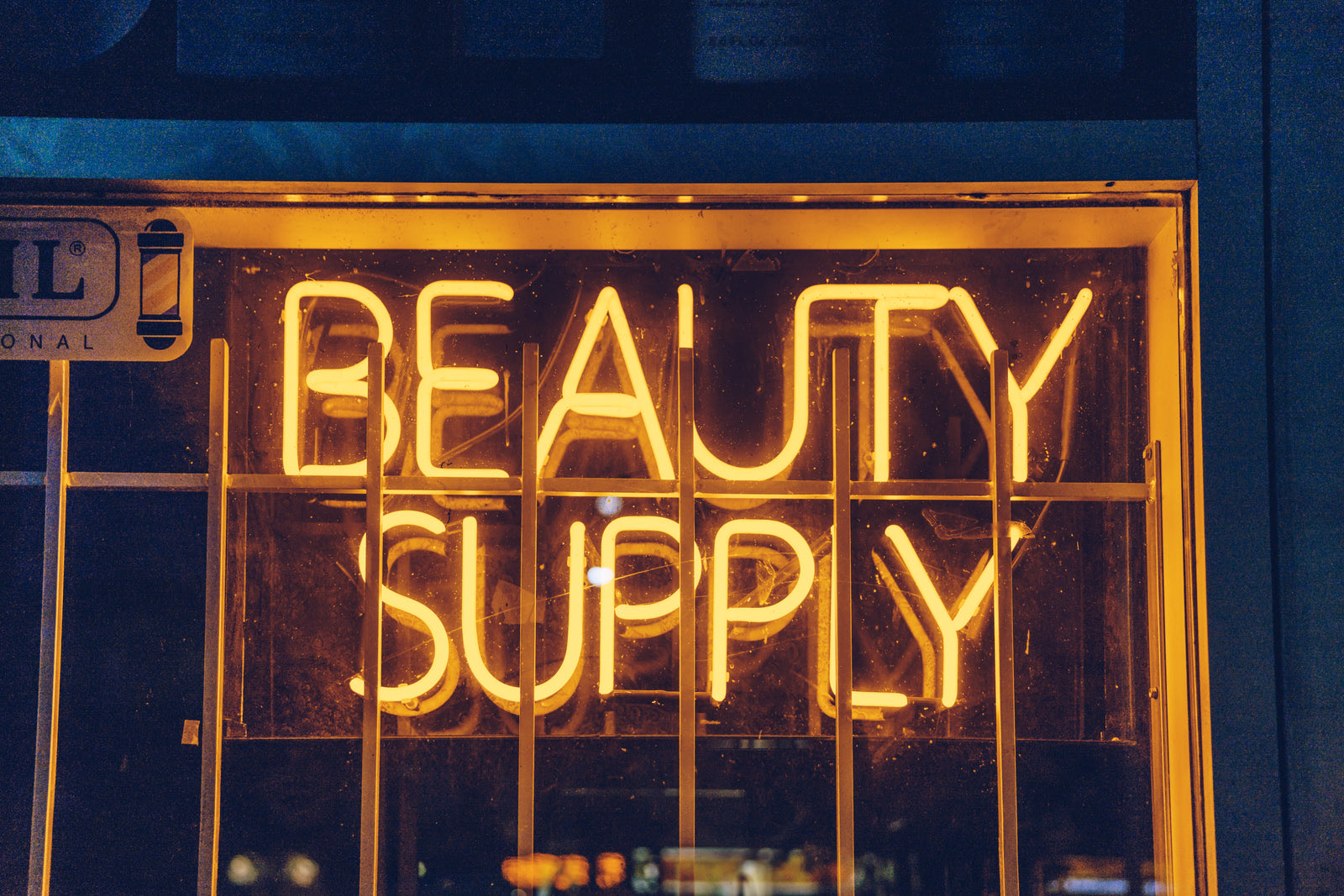 Branded beauty salon storefront in an Indian city with customers visible inside