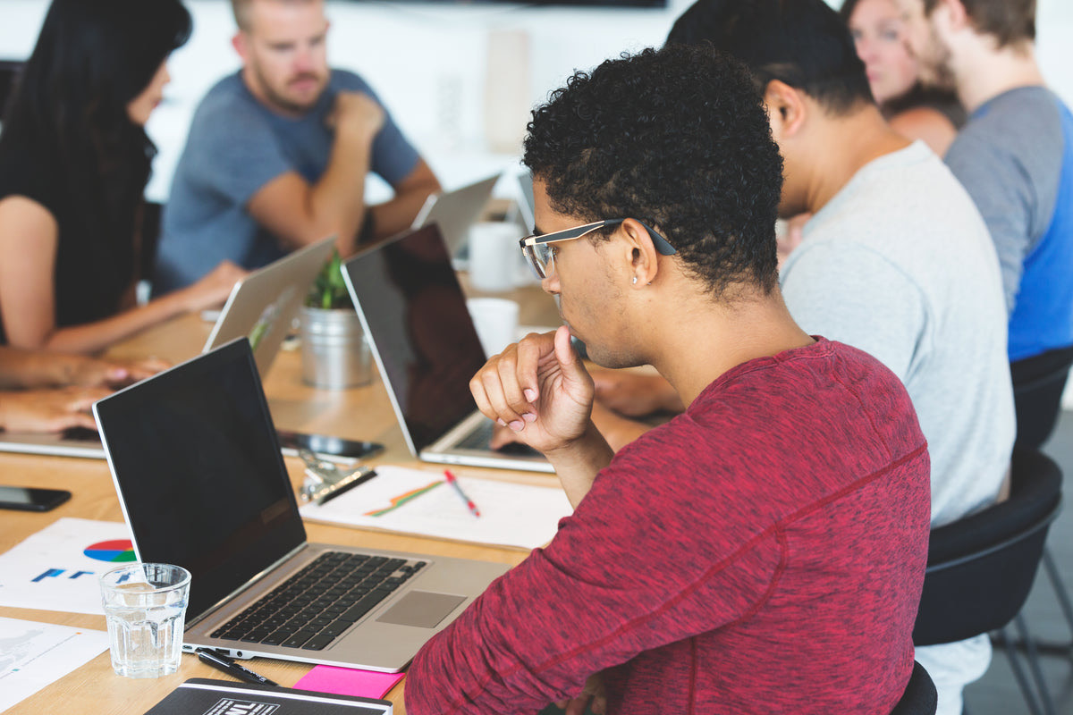 Professionals working at shared desks in a bright open coworking space