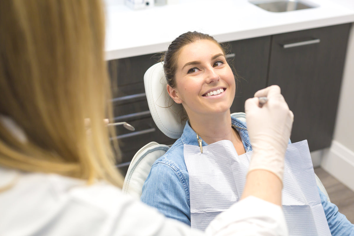 A patient at a dental reception desk confirming an appointment