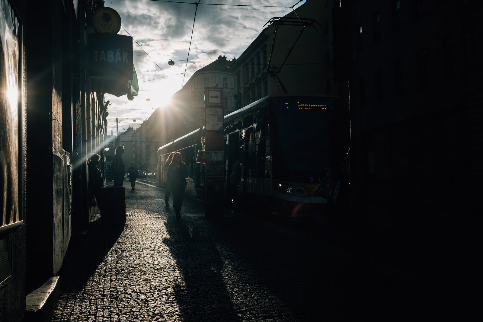 People on a city street using smartphones near large digital billboards