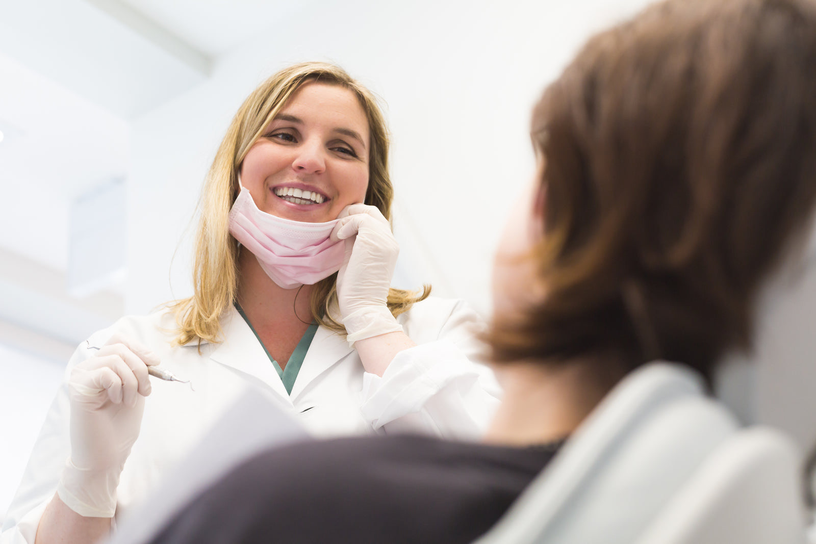 A dentist talking with a patient in the chair