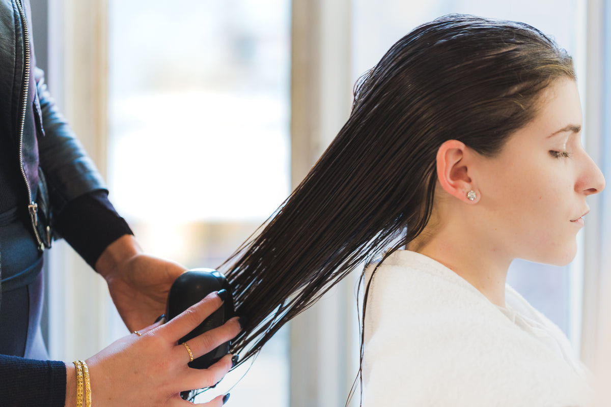 Hair stylist styling a customer's hair in a modern Indian salon