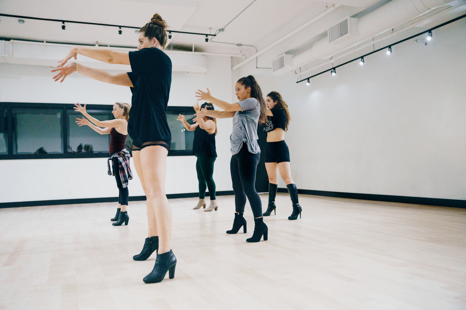 Pilates studio with a row of reformers and an instructor guiding a small class
