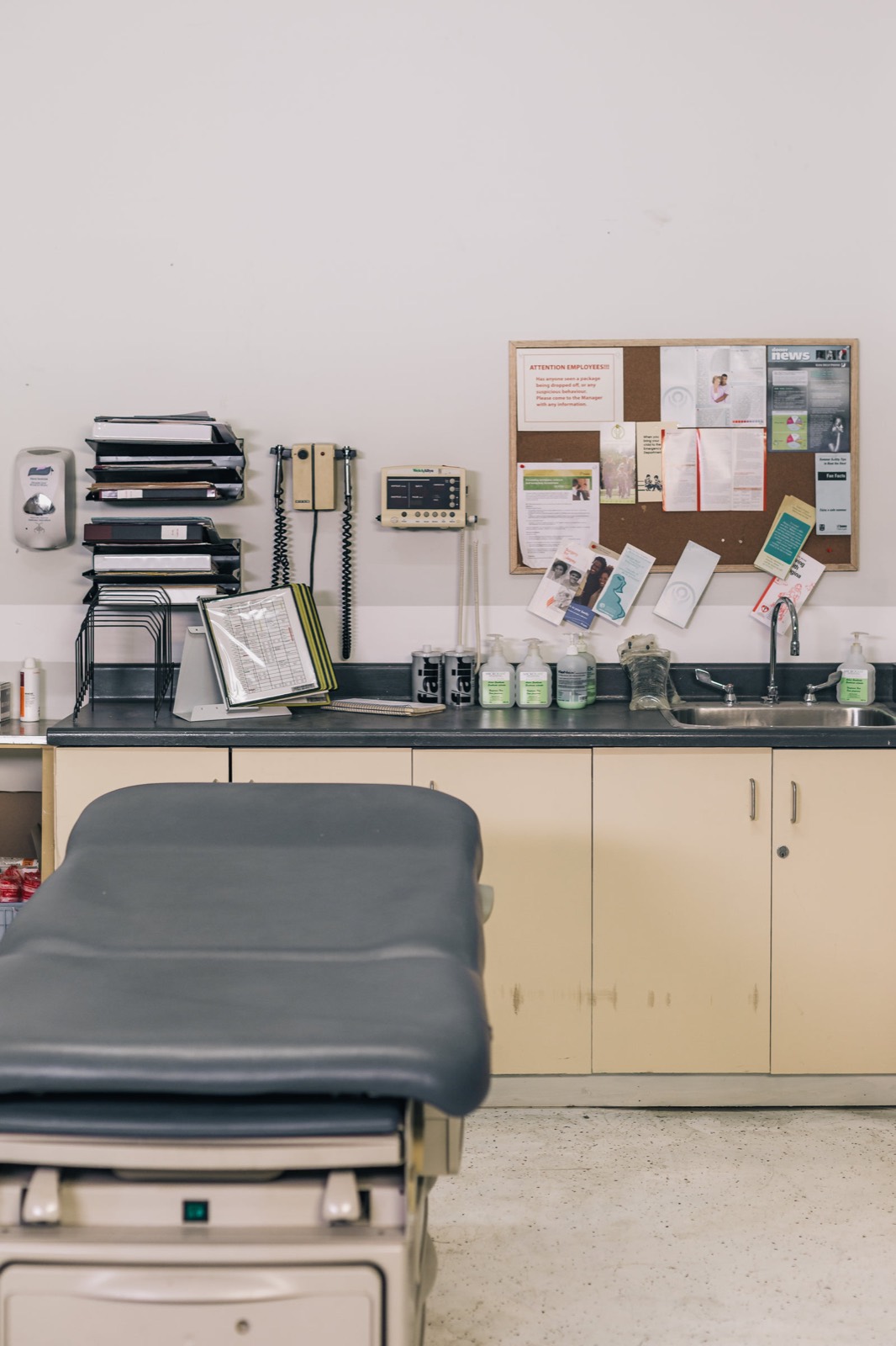 Modern medical clinic waiting room with patients reading near a reception desk