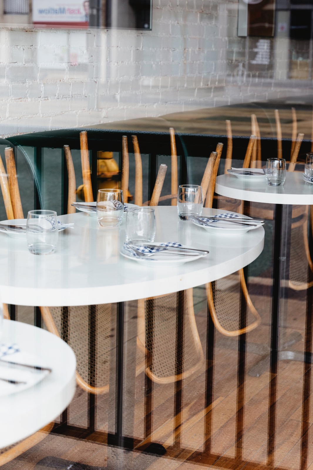Host stand at the entrance of a busy restaurant greeting waiting guests with a waitlist screen