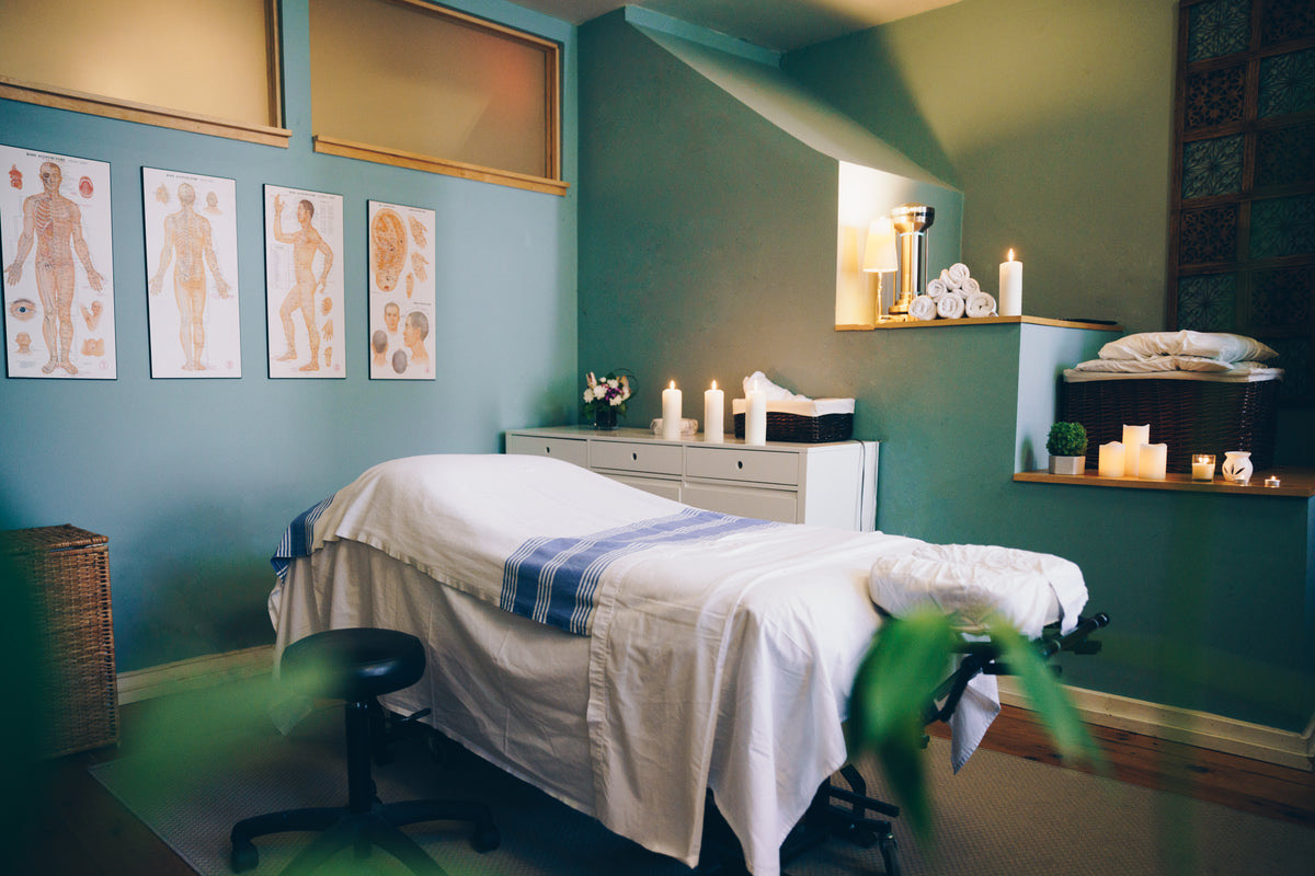 A prepared spa massage room with candles and fresh linens